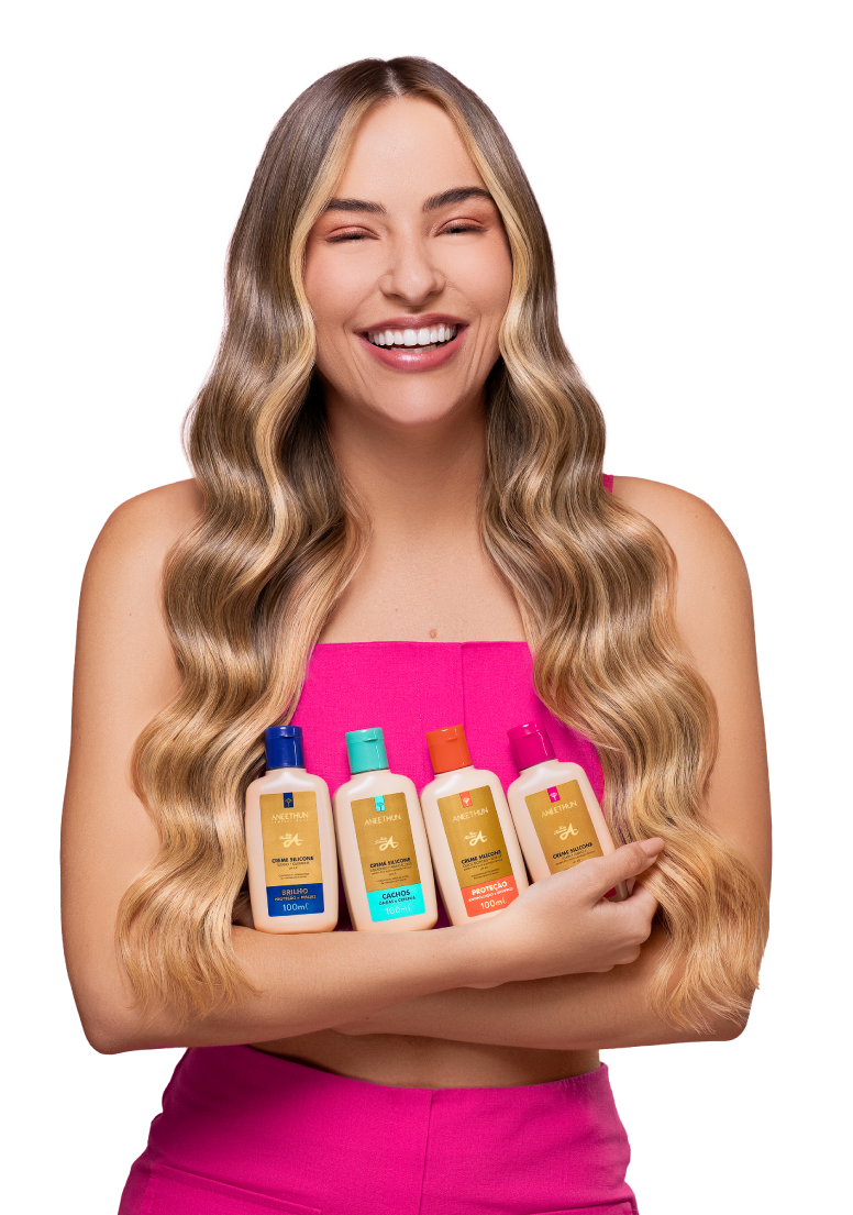 Modelo branca de cabelos loiros lisos ondulados usa vestido rosa e carrega nos braços os frascos de 100 mililitros de todos os produtos da Linha A Creme Silicone: Brilho, Cachos, Proteção e Antidano.